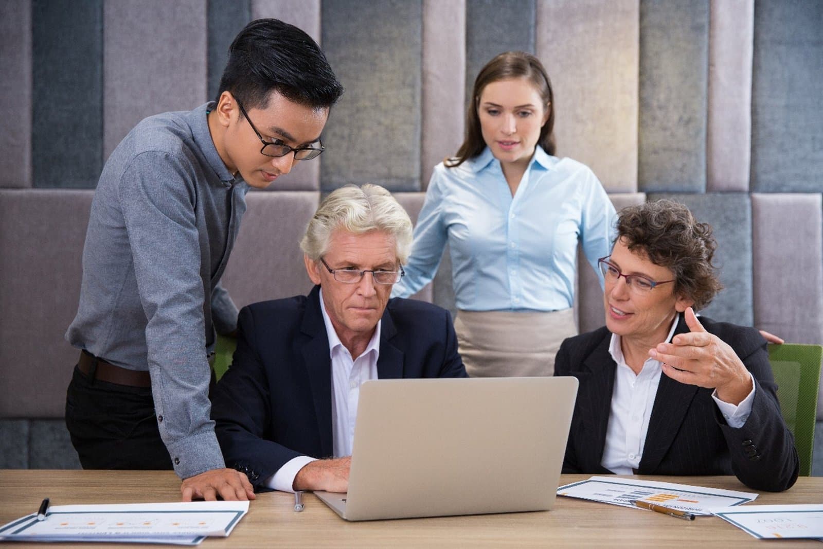 A family reviewing company documents together around a laptop