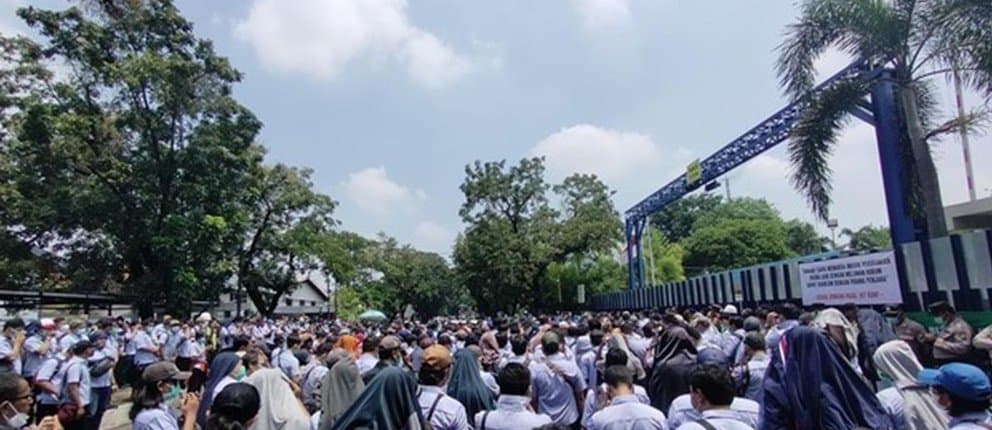 Factory workers gathered outside a company gate during a labor dispute