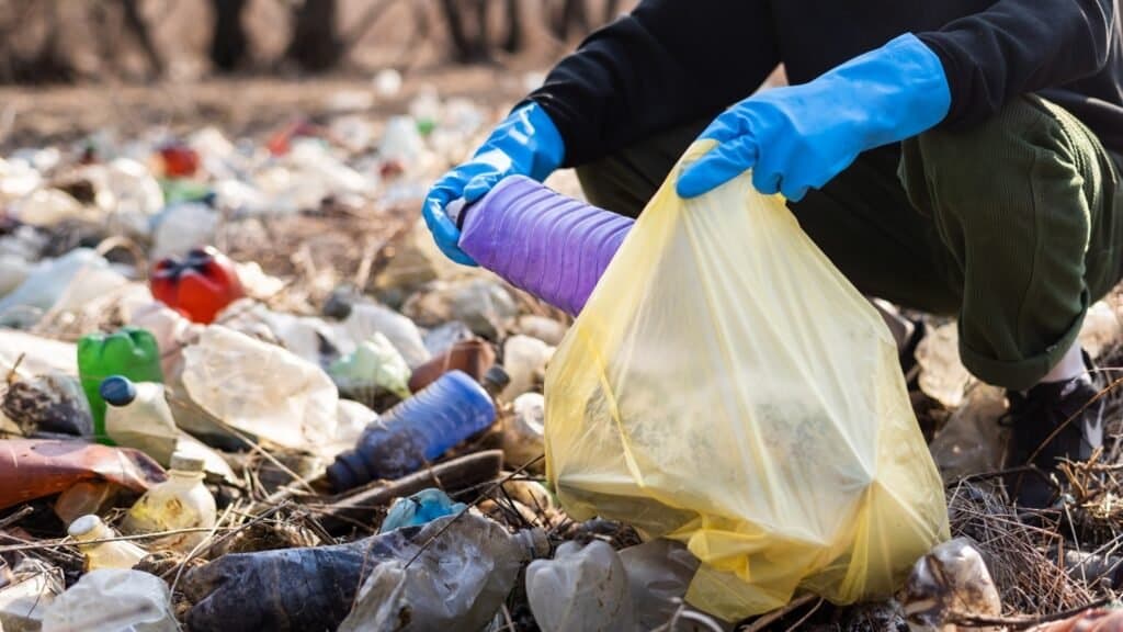 A person collecting plastic waste by hand